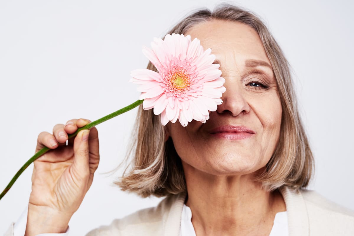 Ältere Frau mit Blume